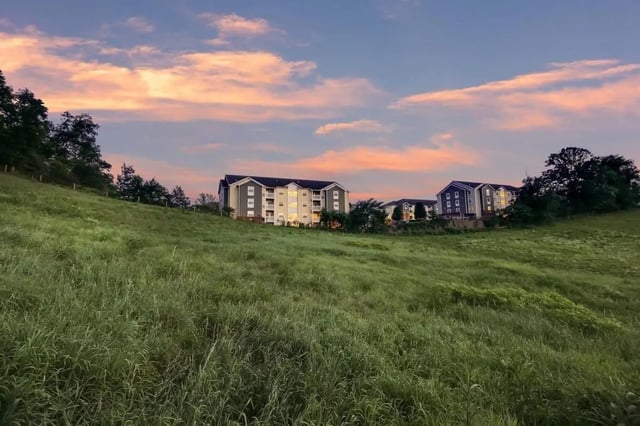 Apartment buildings on grassy hill exterior at West Run Morgantown in Morgantown Student Accommodation