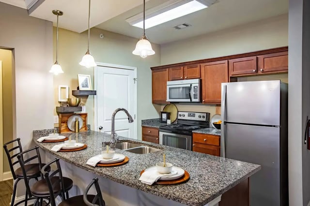 Kitchen island with seating microwave oven and refrigerator kitchen at Midtown at WKU in Bowling Green Student Accommodation