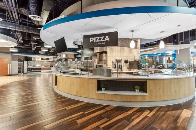 Pizza counter with food display dining hall interior at University Center in Chicago Student Accommodation