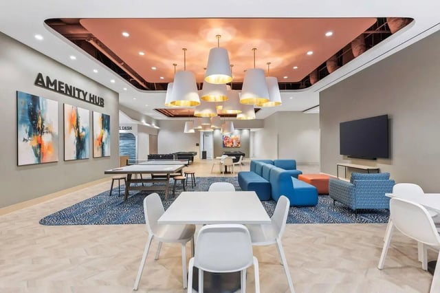 Amenity hub with tables couches and artwork lounge area at University Center in Chicago Student Accommodation