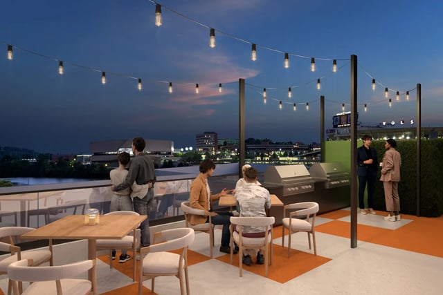 People dining on a rooftop patio with grills exterior at Villas Knoxville in Knoxville Student Accommodation