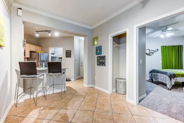Bar stools kitchen doorway and bedroom living room at Villas On Guadalupe in Austin Student Accommodation