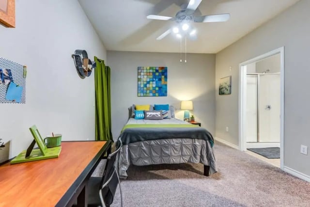 Bed desk ceiling fan artwork and bathroom bedroom at Villas On Guadalupe in Austin Student Accommodation