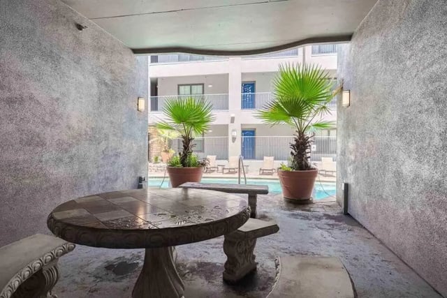 Stone table and benches by pool exterior at Villas On Guadalupe in Austin Student Accommodation
