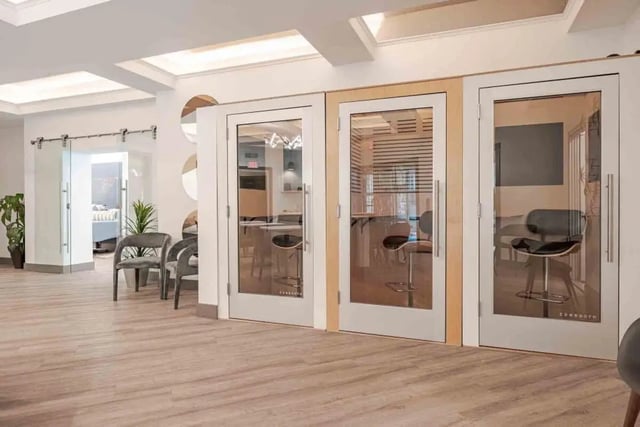 Three glass-walled booths with chairs and tables communal area at Villas On Guadalupe in Austin Student Accommodation