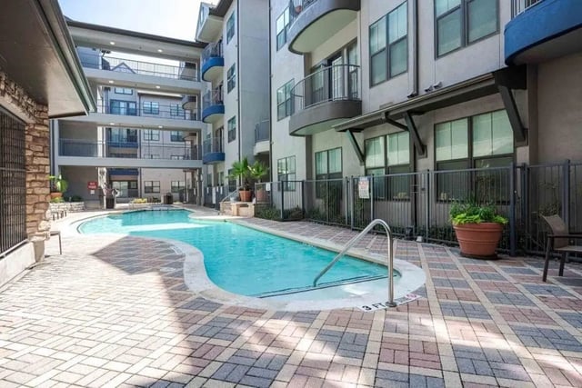Outdoor swimming pool with surrounding patio and buildings exterior at Villas On Guadalupe in Austin Student Accommodation