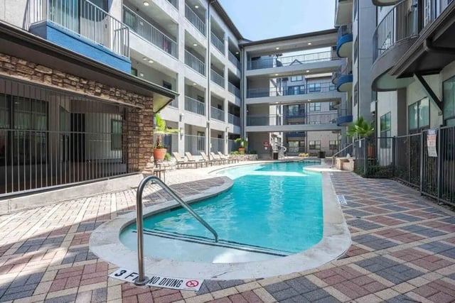 Swimming pool with lounge chairs building exterior at Villas On Guadalupe in Austin Student Accommodation