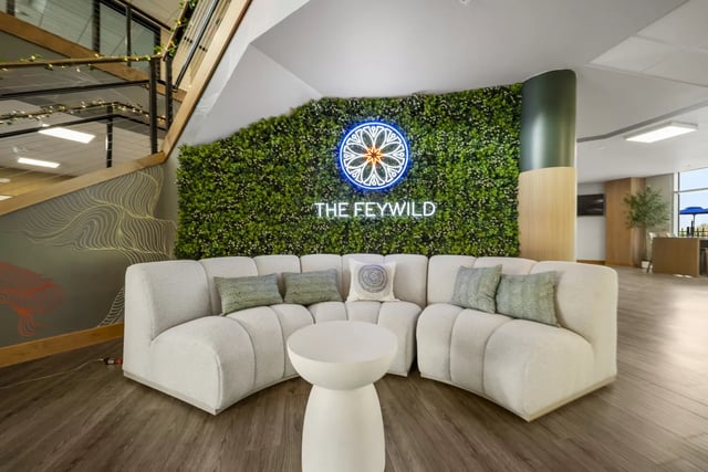 Curved sofa green wall with neon sign living room at The Hill at Rochester in Rochester Student Accommodation