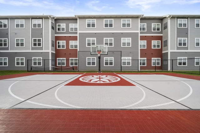 Basketball court with building exterior and fence Playing area at The Hill at Rochester in Rochester Student Accommodation