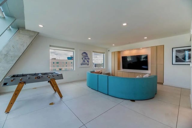 Foosball table blue curved sofa television living room at Villas on Rio in Austin Student Accommodation