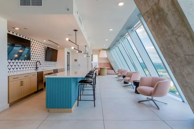 Bar with stools and pink chairs living area at Villas on Rio in Austin Student Accommodation