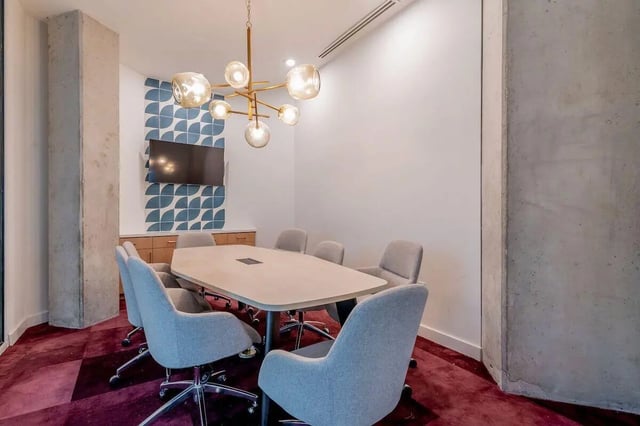 Table chairs television and chandelier meeting room at Villas on Rio in Austin Student Accommodation