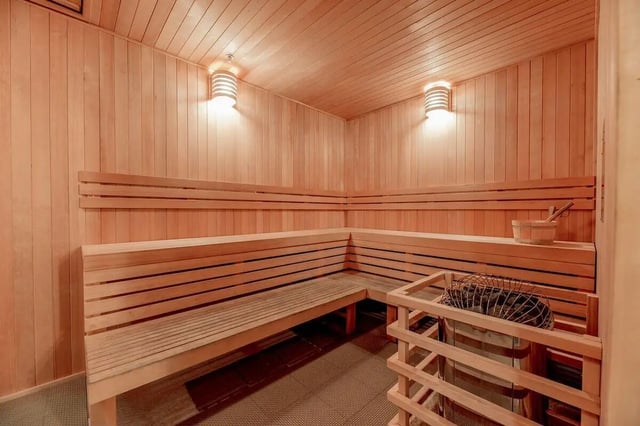 Wood sauna benches and heater with bucket sauna at Villas on Rio in Austin Student Accommodation