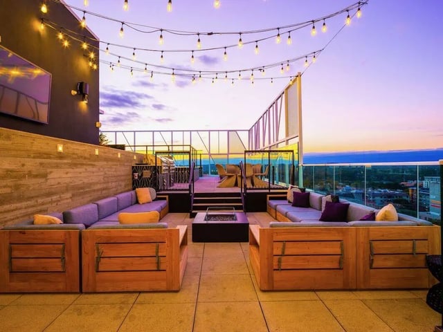 Rooftop lounge with sofas fire pit and city view exterior at Villas on Rio in Austin Student Accommodation