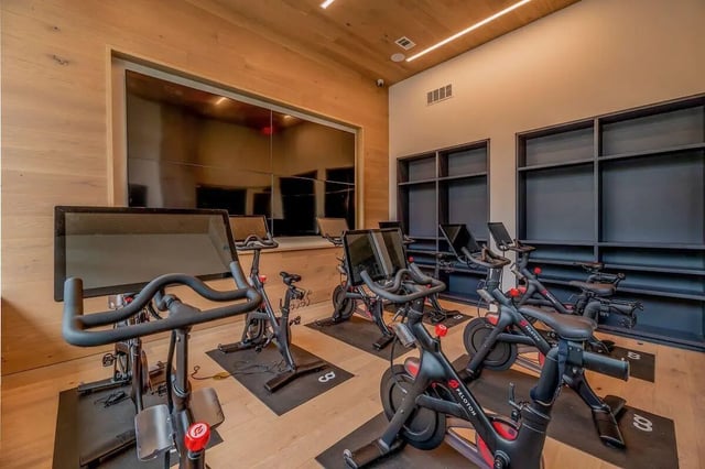 Stationary bikes with screens fitness room at Villas on Rio in Austin Student Accommodation