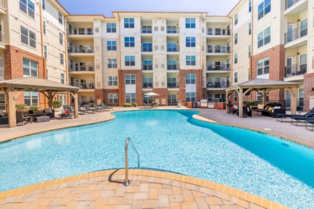 Apartment building with pool and seating exterior at The Pavilion at North Grounds Apartments in Charlottesville Student Accommodation