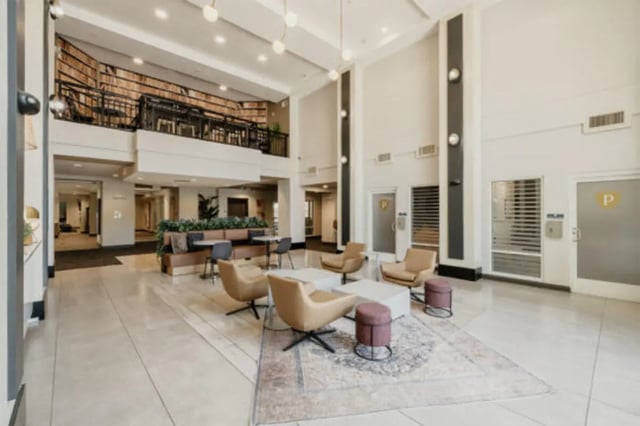 Lobby with chairs tables and bookshelves living room at The Pavilion at North Grounds Apartments in Charlottesville Student Accommodation