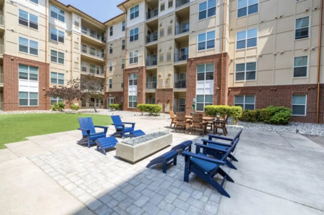 Blue chairs fire pit tables and building exterior at The Pavilion at North Grounds Apartments in Charlottesville Student Accommodation