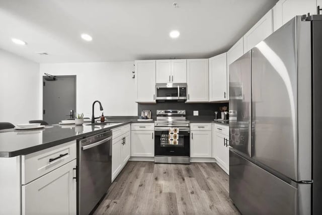 Modern kitchen with stainless steel appliances and white cabinets Kitchen at The Hive in Atlanta Student Accommodation