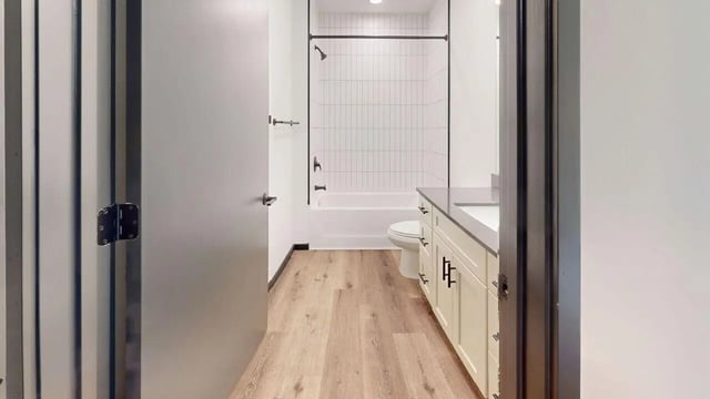 Tub toilet vanity with white cabinets bathroom at The Hive in Atlanta Student Accommodation