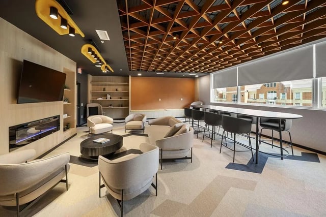 Modern lounge with fireplace TV couches and communal table lounge at The Hive in Atlanta Student Accommodation