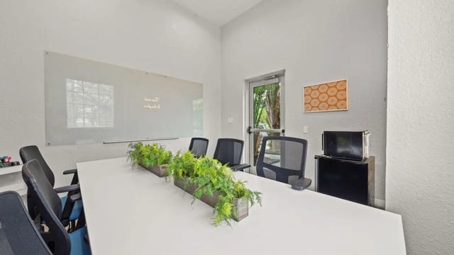 Conference table with chairs and whiteboard study area at Station 42 in Tampa Student Accommodation
