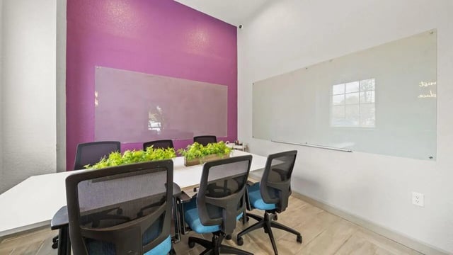 Conference table chairs whiteboards green plants conference room at Station 42 in Tampa Student Accommodation