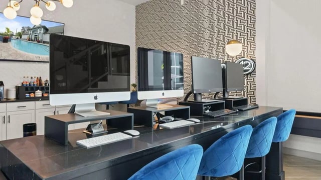 Computers with keyboards and blue chairs study area at Station 42 in Tampa Student Accommodation