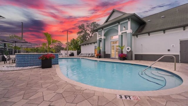 Pool with lounge chairs and colorful sunset exterior at Station 42 in Tampa Student Accommodation