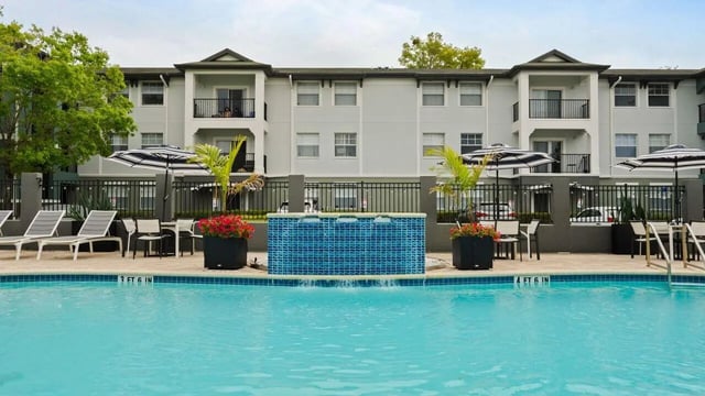 Pool lounge chairs umbrellas and building exterior at Station 42 in Tampa Student Accommodation