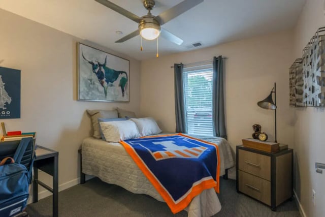 Bed with blue blanket desk and artwork bedroom at Latitude Apartments in Champaign Student Accommodation