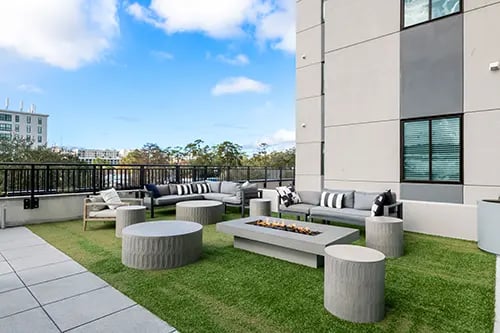 Rooftop patio with sofas fire pit outdoor seating area at Nine 31 Apartments in Gainesville Student Accommodation