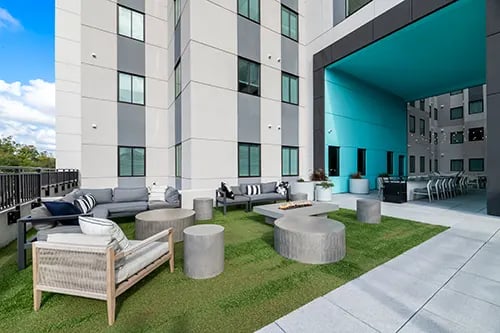 Outdoor lounge area with seating and tables exterior at Nine 31 Apartments in Gainesville Student Accommodation