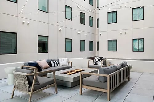 Outdoor seating area with sofas fire pit patio exterior at Nine 31 Apartments in Gainesville Student Accommodation