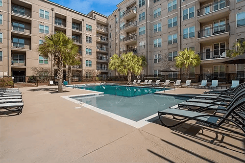 Apartment building with pool and lounge chairs exterior at Station at Five Points in Columbia Student Accommodation