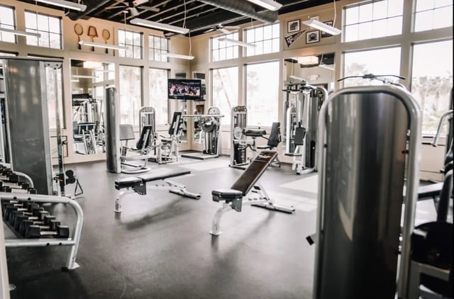 Gym equipment weights benches television playing area at The Cottages of College Station in College Station Student Accommodation