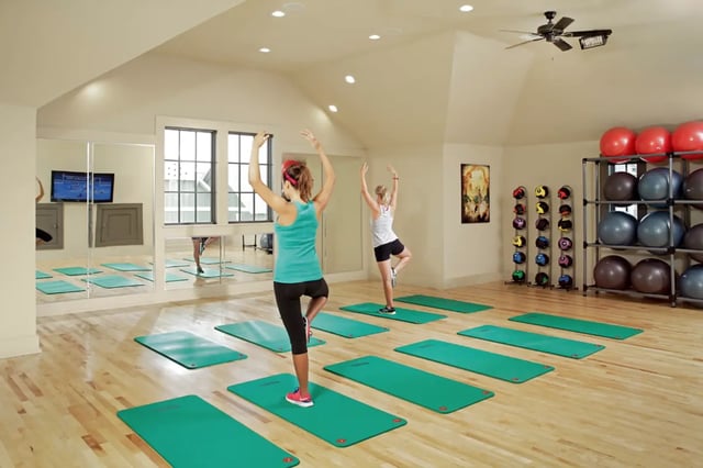 Yoga mats with women exercising fitness room at The Cottages of College Station in College Station Student Accommodation