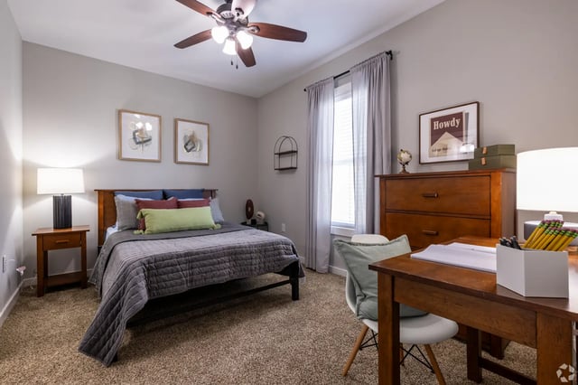 Bed nightstand dresser desk and chair bedroom at The Cottages of College Station in College Station Student Accommodation