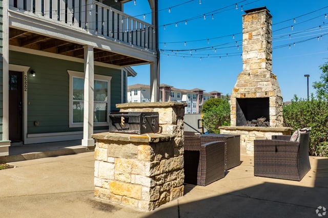 Grill fireplace patio furniture exterior at The Cottages of College Station in College Station Student Accommodation