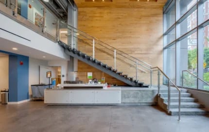 Reception desk and staircase with modern design lobby at Nine East 33rd Apartments in Baltimore Student Accommodation