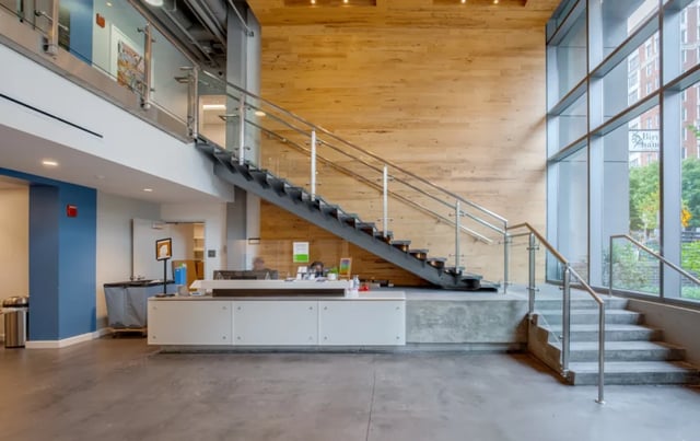 Lobby desk with stairs and windows Lobby at Nine East 33rd Apartments in Baltimore Student Accommodation