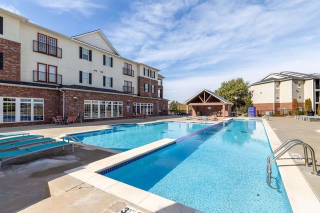 Apartment buildings with swimming pool and lounge chairs exterior at Alight Stillwater in Stillwater Student Accommodation