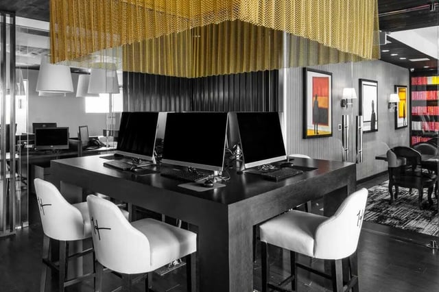 Computers on desk with white stools study area at The Holly in Lubbock Student Accommodation