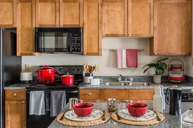 Red pots on stove and place settings kitchen at The Holly in Lubbock Student Accommodation