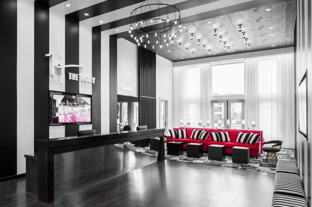Reception desk and red seating area living room at The Holly in Lubbock Student Accommodation