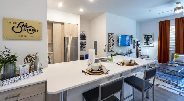 Kitchen island with seating and cabinets living room kitchen at Sterling 5th Street in Davis Student Accommodation