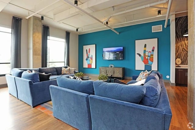 Blue sectional sofas TV and art living room at The Finmore at 241 in Boone Student Accommodation