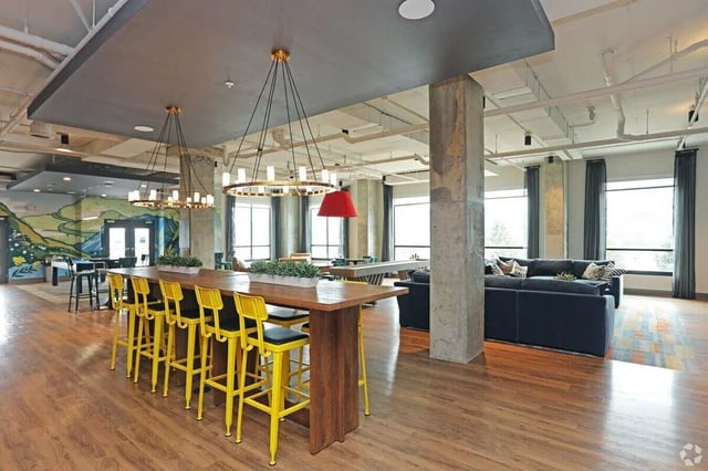 Long table yellow bar stools lounge area living room at The Finmore at 241 in Boone Student Accommodation