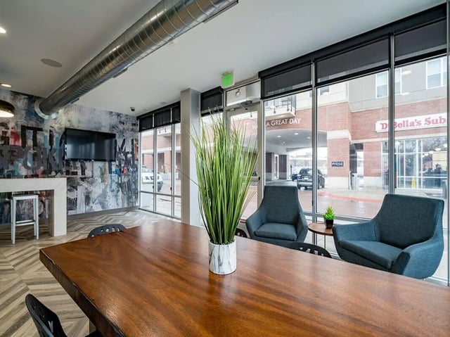Wooden table plant chairs and television lounge area at The Avenue Indianapolis in Indianapolis Student Accommodation