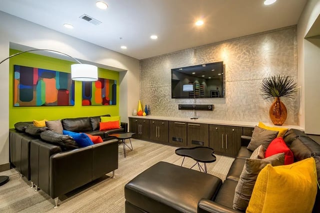 Leather couches abstract art TV mounted living room at The Avenue Indianapolis in Indianapolis Student Accommodation